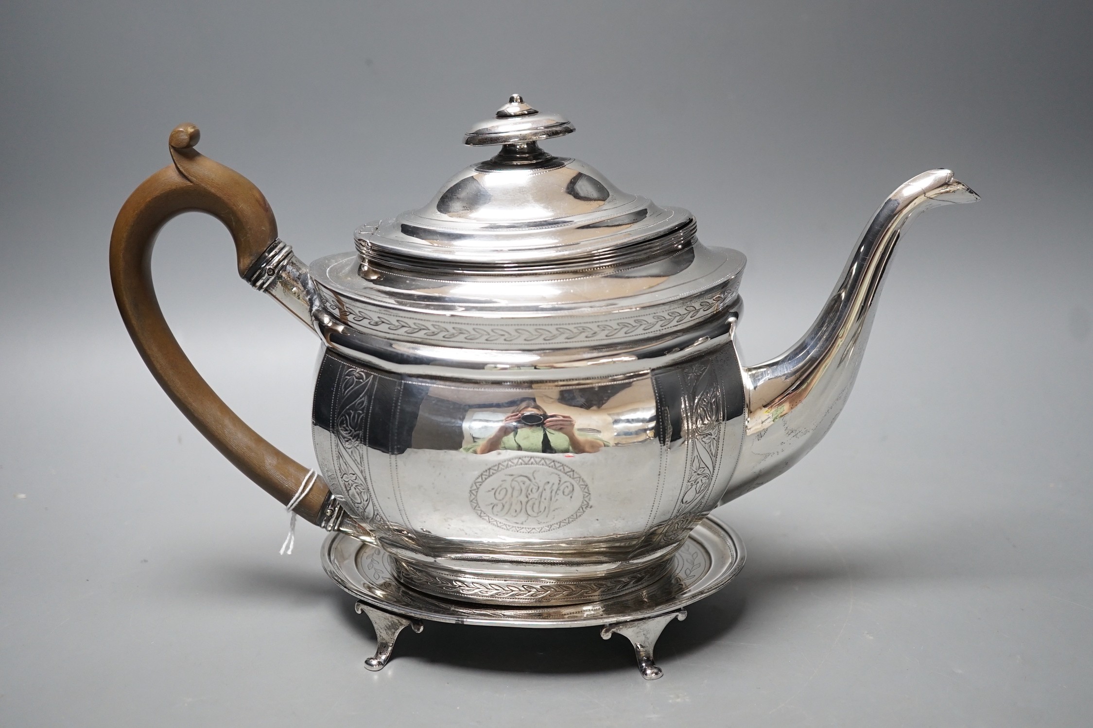 A George III engraved silver oval teapot, Alice & George Burroughs?, London, 1804 and an associated oval silver stand, James Darquits, London, 1805, gross weight 18.3oz.